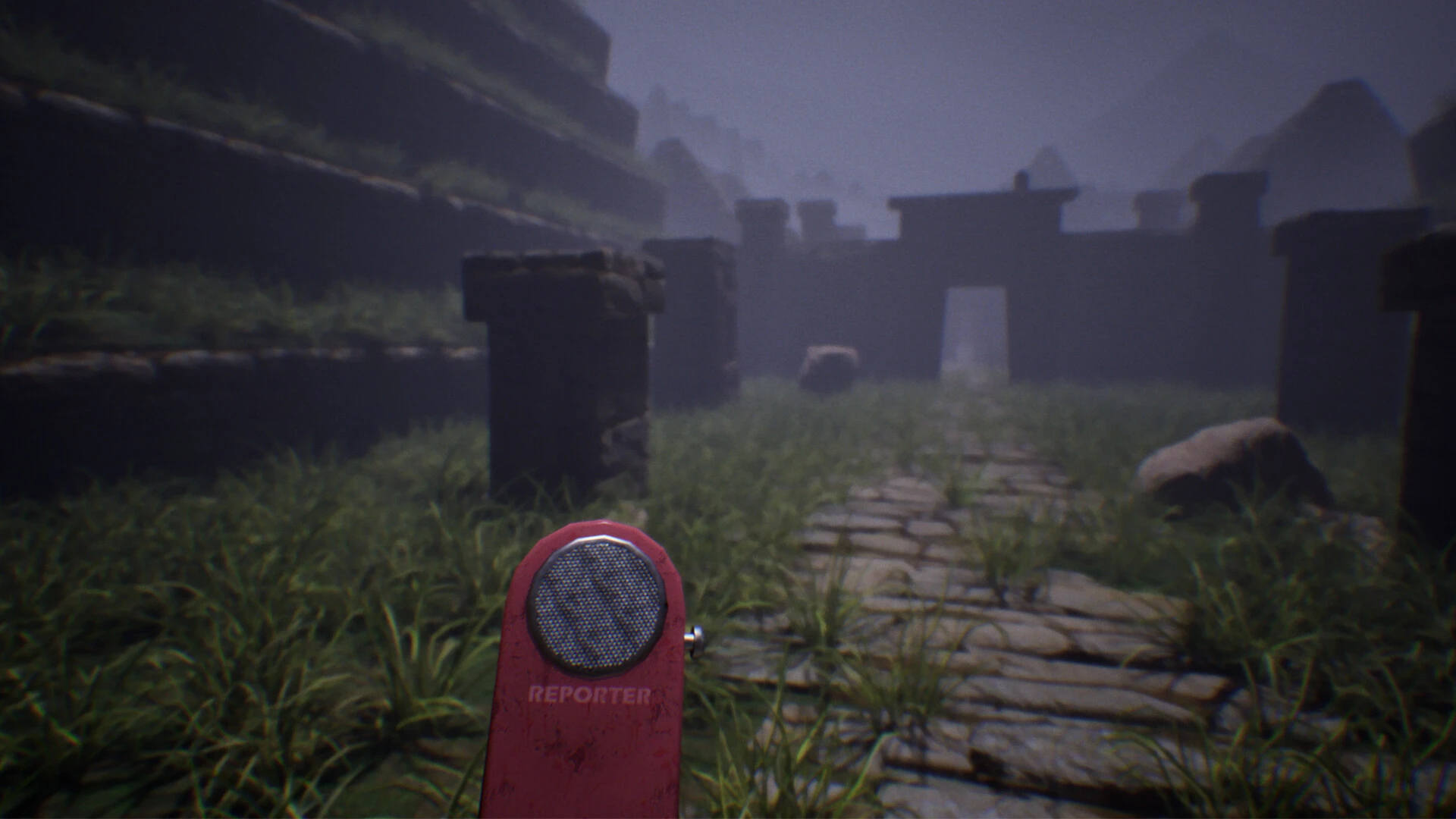 Gameplay Anurak, potecă de piatră acoperită de vegetație printre ruine antice, cu un reportofon roșu în prim-plan.