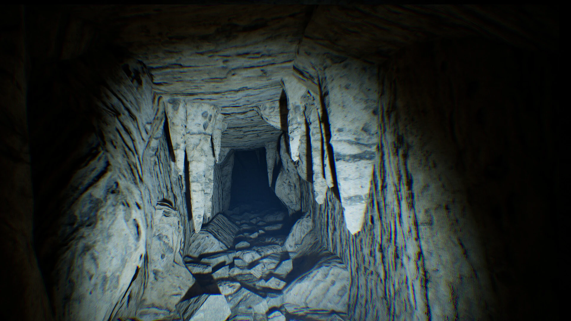Gameplay Anurak, tunel subteran îngust, cu stalactite și pietre prăbușite, luminat de o lanternă.